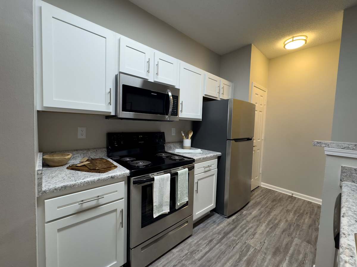 Model apartment: Enclave at Wolfchase kitchen with white cabinets and stainless steel appliances - Memphis, TN